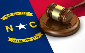 North Carolina US state law code legal system and justice concept with a 3d render of a gavel on the North Carolinian flag on background.